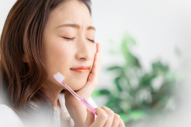 歯の痛みに耐える若い女性