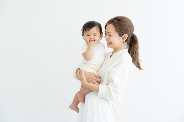 赤ちゃんを抱っこしている笑顔の母親