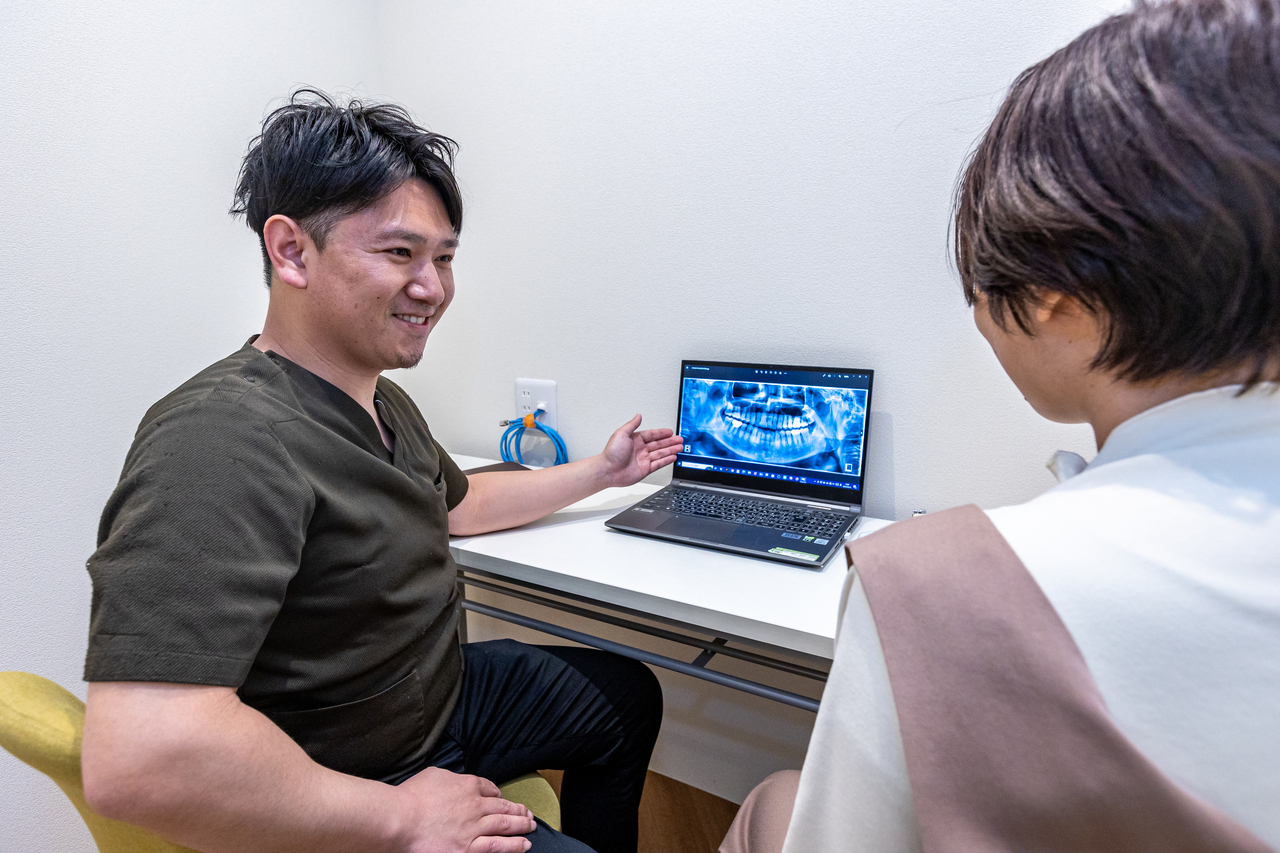 あゆみ歯科クリニックの日野院長が患者へ説明しているところ