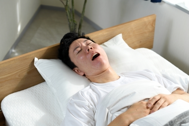 いびきをかいて寝る男性